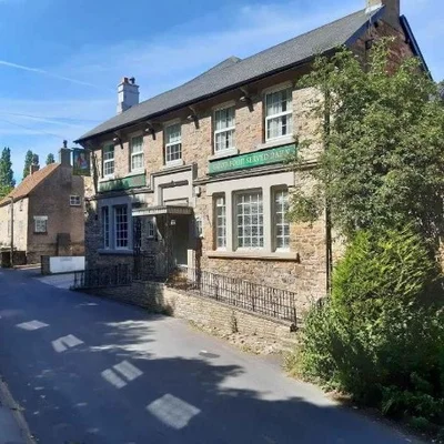 Stone-built pub or inn with traditional windows and signage along a village street