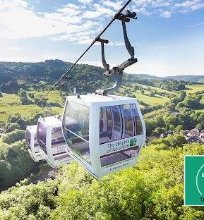 Lush greenery in the background, and a few cable cars in the forefront.