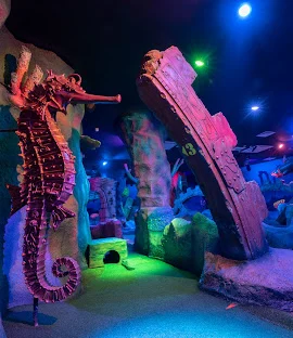 Giant seahorse and rocky structure with a bunch of coloured lights.