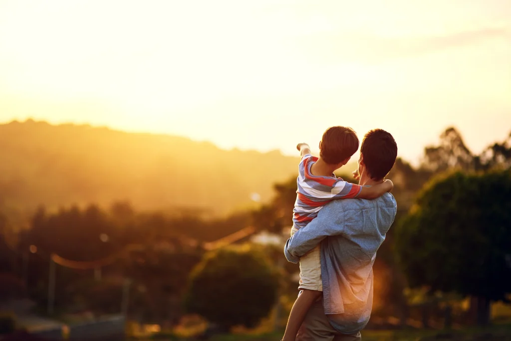 Father carrying son at sunset, enjoying family time near Rother Valley holiday rentals.